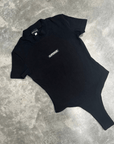 Black t-shirt short sleeve bodysuit with ‘SUPERIOR’ logo on a grey concrete surface for flatlay product shot