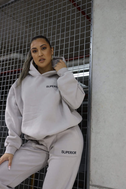 girl posing, left hand on hood, right hand on knee against cage