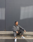 posing in streetwear clothing sitting down on gutter