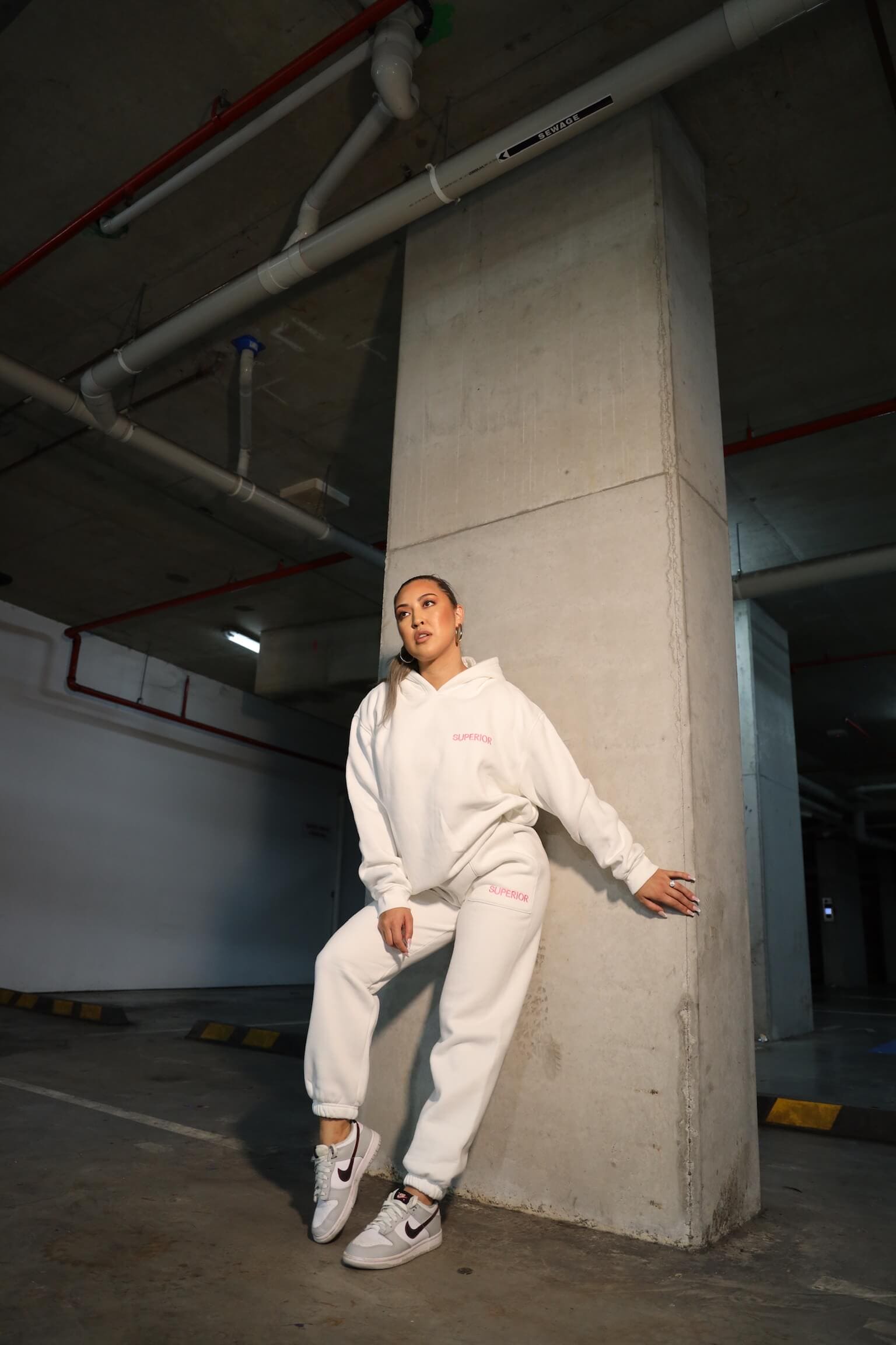 model posing against column in white full set