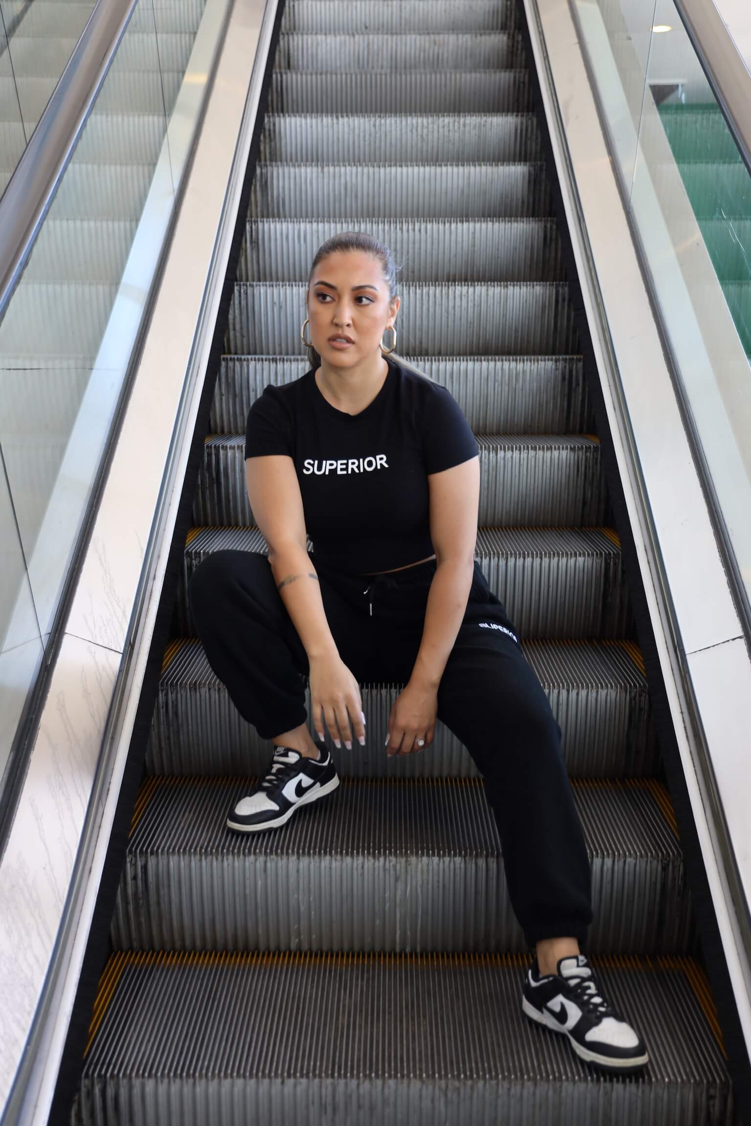 sitting down on escalator with mixed matched outfit