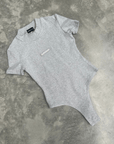 Grey t-shirt bodysuit with a small logo on a textured grey surface for flatlay